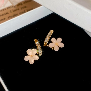 Detailed macro view of 18k gold plated flower earrings with pink petals and zircons