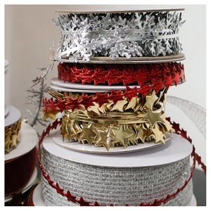 Close-up of stacked Christmas velvet ribbons with cutout snowflake and star patterns