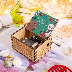 Close-up of wooden hand-crank music box with festive Merry Christmas interior illustration