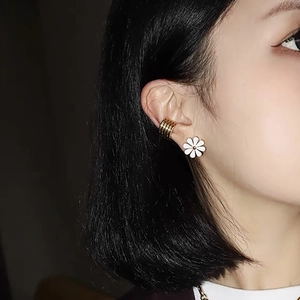 Chic white daisy stud earrings with gold ear cuff on female model for daily style