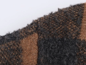 Close-up of the fuzzy plaid knit fabric with dark grey and brown wool texture details
