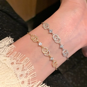 Detail of 18k gold and silver plated bracelets with sparkling zircon interlocking circles