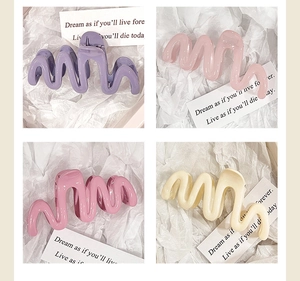 Detail view of large wavy hair claws in jelly colors like purple, pink and cream white