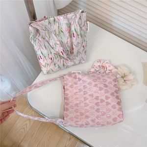 Flat lay of pink floral heart tote bags with matching scrunchies on a white table