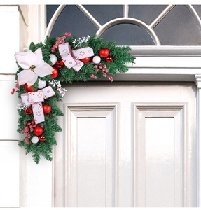 L-shaped Christmas door corner garland with red baubles, white flowers and striped bows