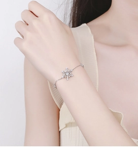 Detail of 925 sterling silver snowflake bracelet with small inlaid diamonds on a wrist