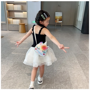 Bambina con borsa a tracolla olografica a forma di unicorno e pompon colorati