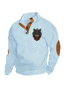 Detail of blue knit sweater with wolf head emblem, brown elbow patches and button collar