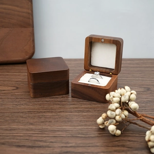 Detail of walnut wood wedding ring box featuring magnetic closure and double inner slots