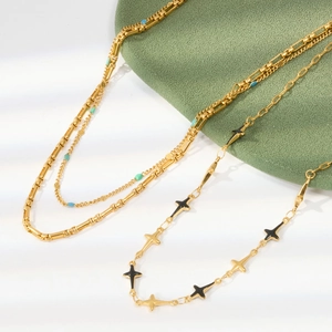 Detail of gold enamel necklaces featuring vintage heart and geometric star pendants