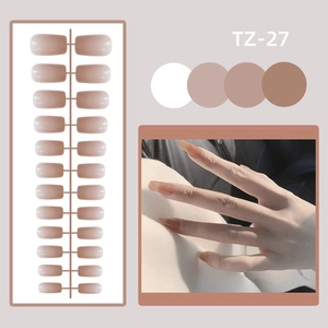 Detail of nude pink glossy press-on nails set in long round shape with mirrored finish
