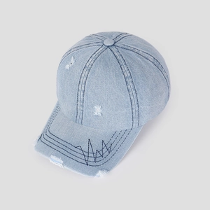 Detail of light blue distressed denim baseball cap with black wave embroidery and torn effects