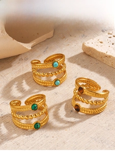 Vue macro détaillée de bagues dorées de style bohème avec incrustations de turquoise et malachite