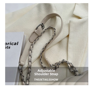 Detail of adjustable metal chain and leather strap on a beige quilted shoulder bag