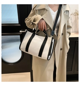 Detail of canvas tote bag with contrast black straps and adjustable shoulder strap