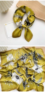 Detail of silk-feel mustard yellow square scarf with white floral and insect patterns