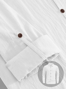 Detail of white linen shirt sleeve with rolled cuff and wooden button texture