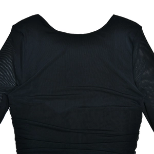 Détail de robe moulante noire avec manches en mesh et fronces élégantes au dos