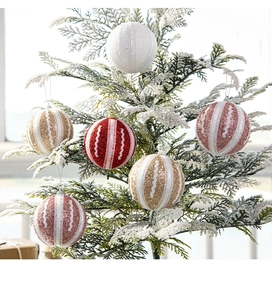 Nahaufnahme von rosa und goldfarbenen Glitzer-Weihnachtskugeln an einem verschneiten Baum