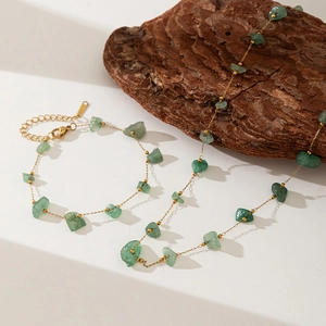 Detail of gold stainless steel necklace and bracelet set with green natural stone beads