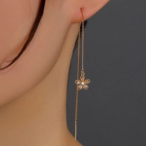 Detailed close-up of a long tassel rose gold earring featuring a sparkling zircon flower