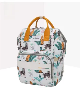 Detail of printed diaper bag with giraffe patterns and padded yellow handles