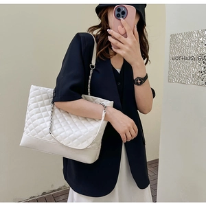 Vue détaillée d'un grand sac cabas blanc matelassé avec bandoulière à chaîne sur modèle