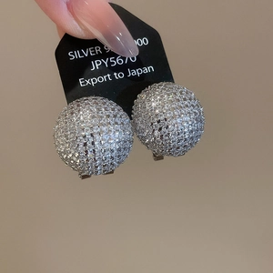 Detailed macro view of S925 silver pave-set zircon ball earrings with brilliant shine