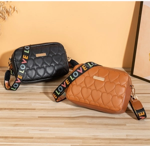 Detail of heart-quilted crossbody bags with colorful LOVE letter wide fabric straps