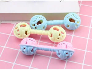 Three macaron-colored baby dumbbell rattles with spiral textured handles on a soft background