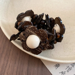 Macro shot of ethnic coconut shell beads and white center pearls on a wood beaded bracelet