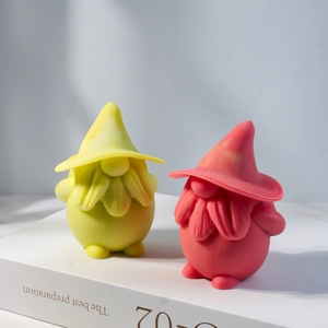 Macro detail of gnome-shaped plaster candle ornaments in yellow and coral pink colors