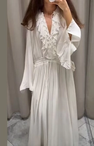 Detailaufnahme von V-Ausschnitt mit Rüschen und Bindedetails am weißen Maxikleid
