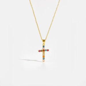 Macro shot of gold S925 sterling silver cross pendant with vibrant multi-colored zircon stones