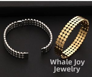 Gros plan de bracelets triple rangée en acier inoxydable or et argent sur fond noir