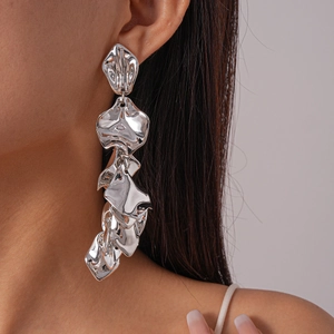 Close-up of oversized liquid-metal silver petal earrings worn on the ear model