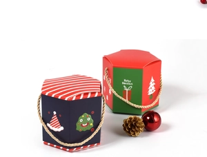 Detail of hexagonal Christmas gift boxes with festive patterns and gold rope handles