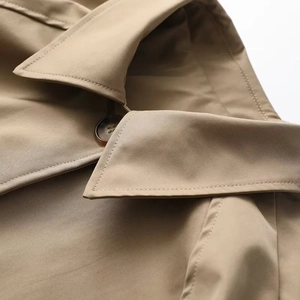 Detail eines khakifarbenen Windbreakers mit Reversnähten und Bernstein-Knöpfen