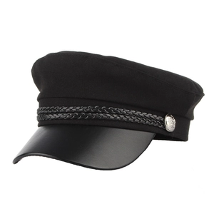 Detail of black newsboy hat with braided rope decoration and silver embossed metal button