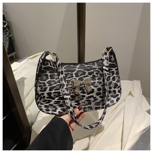 Close-up of leopard print shoulder bag featuring a vintage golden butterfly metal clasp