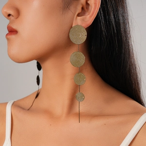 Close-up of matte gold cascading round geometric earrings with fine spiral texture