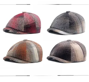 Detailed view of winter newsboy caps in red, grey, orange, and brown herringbone tweed