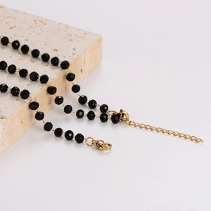 Elegante collana Albero della Vita con perle sfaccettate nere e catena d'oro su pietra