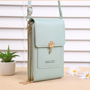 Detail of mint green PU leather mobile bag with golden flower charm and multi zippers