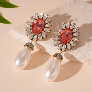 Macro detail of vintage baroque earrings with red oval stones and teardrop pearls
