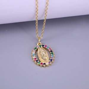 Macro view of gold Virgin Mary oval pendant with colorful rhinestones on a fine chain