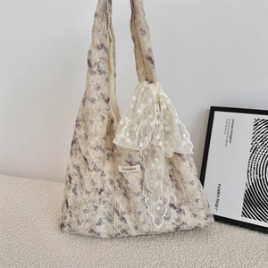 Close-up of floral canvas tote bag featuring lace trim and a large mesh bow accessory