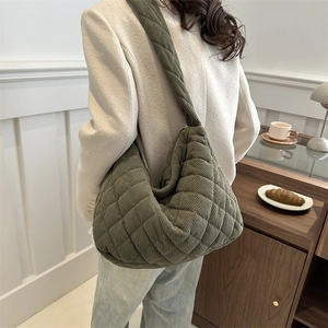 Green quilted corduroy crescent hobo bag with drawstring detail shown on model