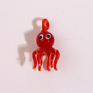 Macro shot of a red glass octopus pendant with detailed tentacles and glossy finish