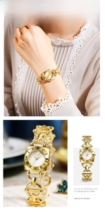 Macro shot of gold-plated women's chain watch with Roman numerals and elegant bracelet
